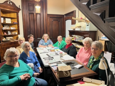 The Auction Planning Committee gathered on March 7 at the Richardson-Bates House Museum. From left to right: Lyn Patterson, Charlene Mitchell, Carol Shannon, Greg Caster, Co-Chair Jennifer Bertollini, Peg McKinstry, Co-Chair Mary Kay Stone, and Mary Shanley. Photo courtesy of Eva Corradino.