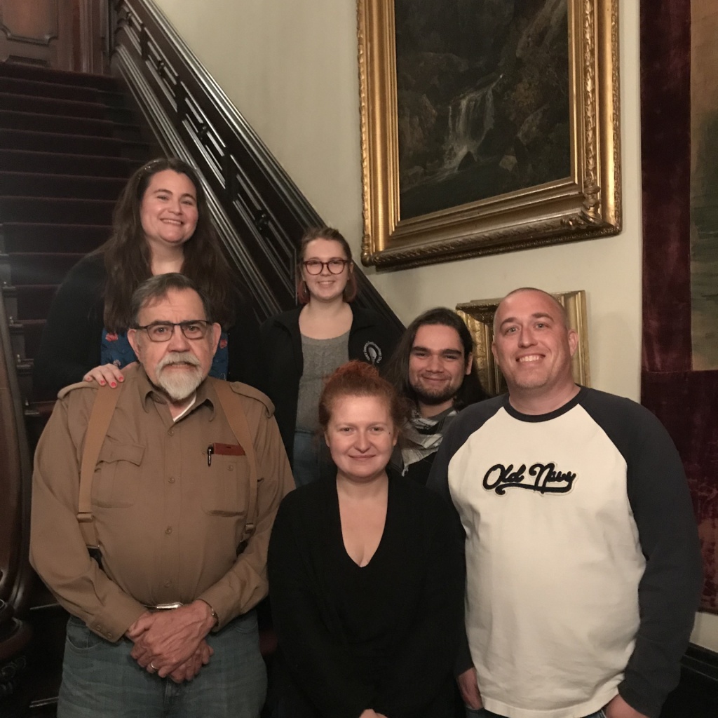 Anthropology club students stand at the base of the stairs in the Richardson-Bates House Museum's front hall.