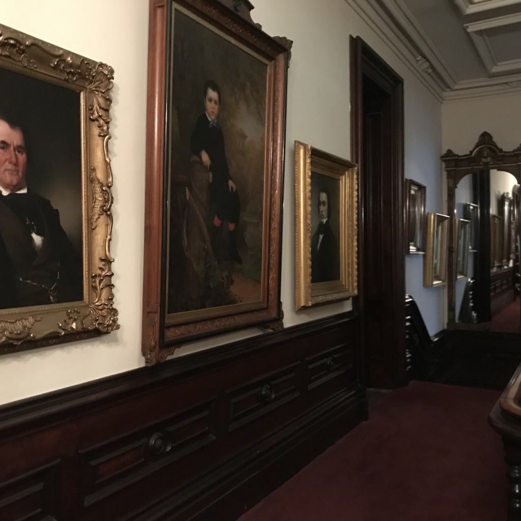 The Upper Hallway has a series of family portraits with Jesse Bennett  (Max Richardson' grandfather) on the left, Noran Bates at about 7 years old in the center, and Jacob Richardson (Max's father) on the right. Naomi Bennett Richardson and Harriet Richardson Bates's photos are past the doorway.